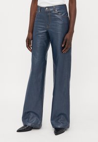 Wijdvallende denim jeans in donkerblauw, met een gladde textuur, contrasterende stiksels en een klassiek vijf-pocket ontwerp.