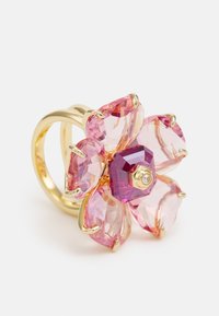 Anillo chapado en oro con un diseño de flor que presenta cinco pétalos de gema rosa y un acento central de gema rosa profunda, reflejando la luz con una superficie facetada.
