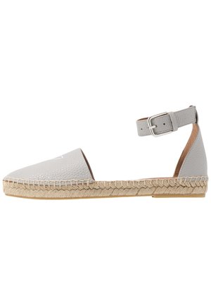 Vaaleanharmaa nahkainen espadrille-kengän malli, jossa on terävä kärki, punotusta jute-kumipohja ja säädettävä nilkkahihna hopeanvärisellä soljella.