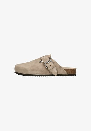 Beige Wildleder Clogs zum Hineinschlüpfen mit abgerundeter Spitze, verstellbarer silberner Schnalle und strukturiertem, korkähnlichem Außensohle. Flache Sohle mit geriffeltem Muster.
