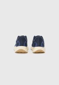 Navy mesh athletic shoes with light beige soles, featuring a textured upper and contrasting blue accents on the sides and heel.