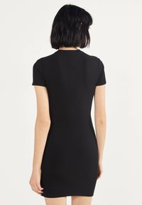 Černé žebrované šaty s krátkým rukávem a přiléhavým střihem, s kulatým výstřihem a hladkou texturou, končícími nad kolenem.