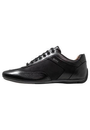 Sleek czarny niski sneaker z skóry i tkaniny z teksturowanym noskiem i piętą, sznurowany, z logo „BOSS” na bocznej panelu.