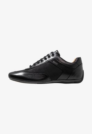 Eleganter schwarzer Leder- und Stoff-Low-Top-Sneaker mit strukturierter Spitze und Ferse, Schnürdesign und „BOSS“-Logo auf dem Seitenpaneel.
