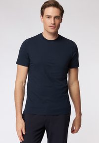 Middengroene kortarm t-shirt in een katoenmix met een ronde hals. Vlotte textuur, aansluitend ontwerp en geen zichtbare patronen of accenten.