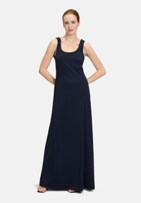 Robe maxi bleu marine avec de larges bretelles, un décolleté rond et un tissu lisse et fluide qui tombe jusqu'au sol.