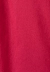 Tessuto di cotone rosso con una superficie liscia e una finitura opaca, privo di motivi o decorazioni visibili. Adatto per vari progetti di cucito.