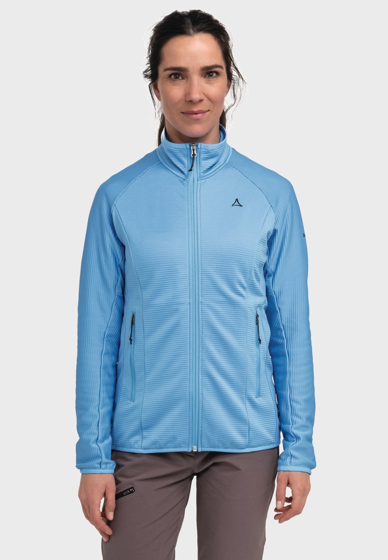 Hellblaue Zip-Jacke aus geripptem Stoff, mit seitlichen Taschen mit Reißverschlüssen, Stehkragen und einem dezenten Logo auf der linken Brust.