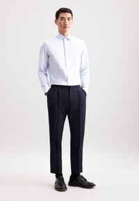 Lichtblauw gestreept overhemd met knopen, marineblauwe geplooide broek, zwarte leren schoenen, met een gladde textuur en een getailleerde pasvorm.