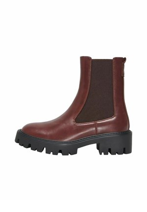 Bottine en cuir marron avec un empiècement latéral élastique foncé, une tirette et une semelle noire épaisse à crampons.
