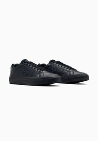 Schwarze Sneakers aus Leder mit glatter Textur, klassischem Schnürdesign und Gummisohlen mit strukturiertem Grip-Muster.