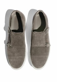 Sive cipele na vezivanje od antilopa s okruglim vrhom i dva podesiva metalna kopčanja. Bijele gumene potplate i šivani detalji za izdržljivost.