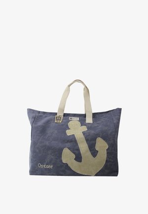 Blue fabric tote bag with a large beige anchor design and beige handles; features a logo tag "Robin Ruth" and embroidered text "Ostsee."