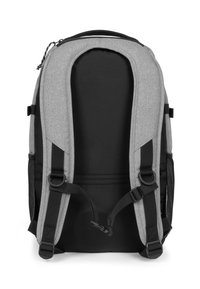 Mochila de tela gris con acentos negros. Cuenta con correas de hombro acolchadas dobles, bolsillos laterales de malla y un asa en la parte superior. Cierre con cremallera.