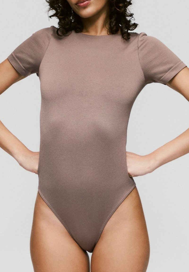 Bruine bodysuit met korte mouwen en hoge beenlijn, gemaakt van een gladde, rekbare stof. Eenvoudig ontwerp, aansluitende silhouet, geen zichtbare patronen.