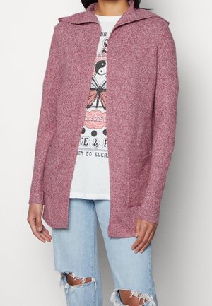Long, open-front cardigan in a textured red fabric with a wide collar, featuring two front pockets and a relaxed fit. Pairing with a graphic tee.