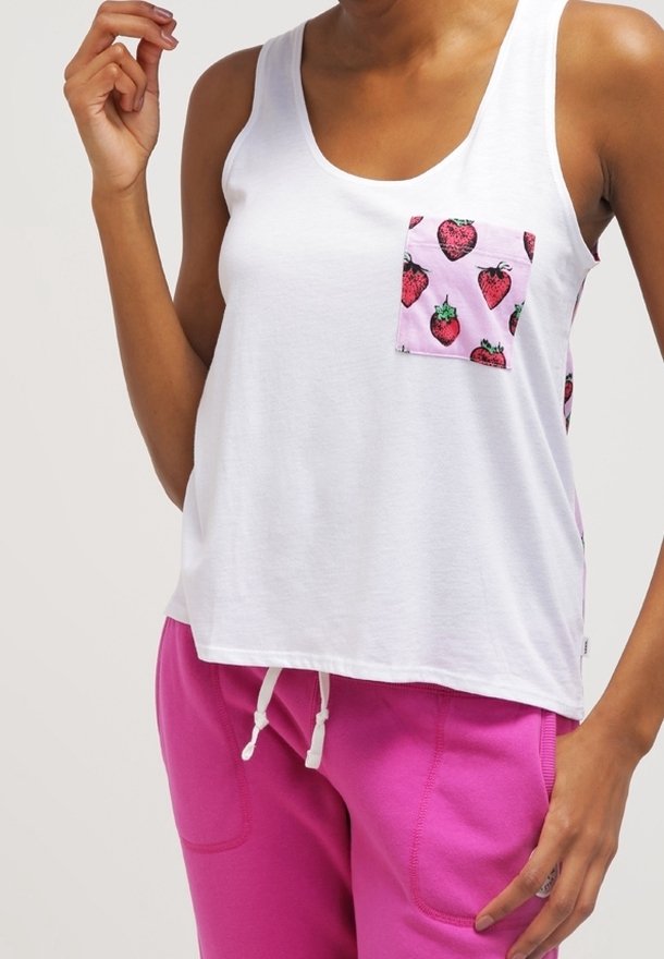 Biała bawełniana tank top z różową kieszenią w truskawkowy wzór. Połączony z luźnymi różowymi spodniami dresowymi. Prosty design i casualowy styl.