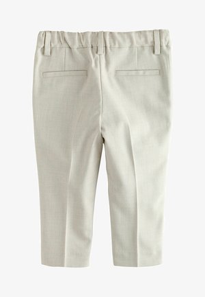 Gaiši bēšas īsas bikses ar gludu tekstūru, elastīgu jostasvietu un divām aizmugures kabatām uz plakana, vienkārša virsmas.