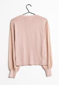 Maglione rosa pallido a maniche lunghe con maniche a sbuffo texturizzate appeso a una gruccia nera su sfondo bianco.