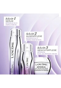 Drei silberne Lancôme Hautpflegeprodukte mit den Bezeichnungen Schritt 1 Serum, Schritt 2 Augenpflege und Schritt 3 Gesichtscreme auf violettem Hintergrund.