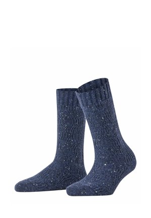 Paire de chaussettes tricotées bleu foncé avec un bord-côtes et de petites mouchetures blanches sur tout le tissu.