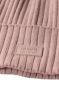 Beanie a coste in rosa morbido, con un tessuto texturizzato e un'etichetta in gomma rettangolare con la scritta "COLORFUL SIDES OF LIFE."
