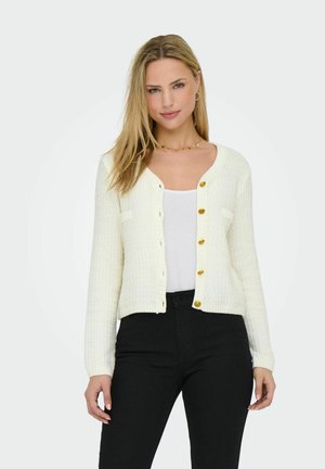 Gebreide cardigan in lichtcrème met een geribbelde textuur, voorzien van een ronde hals, lange mouwen en gele knopen aan de voorkant.
