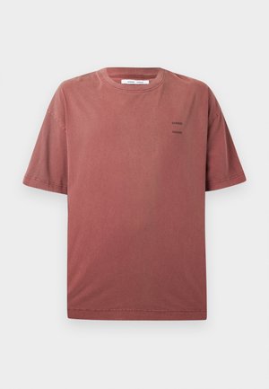 Rövid ujjú, kerek nyakú póló poros vörös színben, puha anyagból készült. Az elején diszkrét fekete szöveg található. Egyszerű, laza szabású.