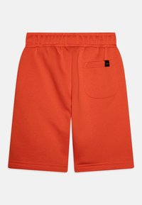 Oranžové sportovní šortky s elastickým pasem, jednou zadní kapsou a hladkou texturou látky. Rovný střih nohavic s prošitými lemy.