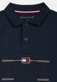 Námornícky polo tričko s rebrovaným golierom s červenými a bielymi prúžkami, dvomi gombíkmi a vyšitým logom "HILFIGER NEW YORK".