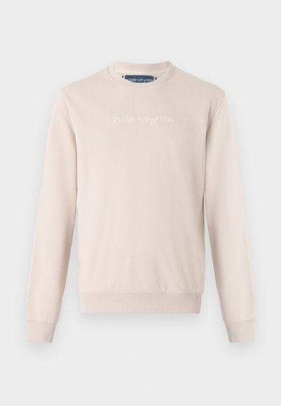 Lys beige sweatshirt med lange ermer, ribbede mansjetter og nederkant, med preget tekst "HOUSE OF JAFFA" over fronten. Glatt stofftekstur.