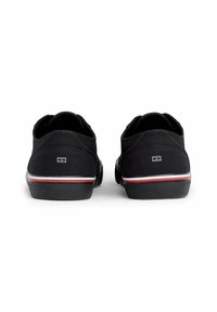 Czarne płócienne buty o zaokrąglonym kształcie, z białą i czerwoną akcentującą pasek wzdłuż podeszwy oraz logo na obcasie.