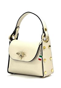 Petit sac à main en cuir ivoire avec un emblème doré en forme d'abeille, des accents noirs et des clous dorés sur le côté. Il dispose d'une courte anse pour le porter.