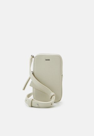 Malá světle béžová kožená crossbody taška s nastavitelným popruhem a stříbrným zipem, na přední straně značka "BOSS".