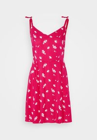 Robe d'été rose à fleurs avec fines bretelles réglables, corsage ajusté et jupe évasée. Le tissu est orné de petits motifs de fleurs blanches.