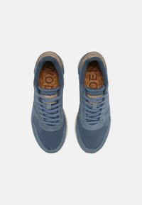 Modré síťované tenisky s korkovými akcenty, šněrovací design, zaoblená špička a textura gumové podrážky. Čisté linie a moderní silueta.