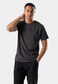 Mørkegrå crew neck t-shirt i blødt bomuldsstof. Korte ærmer, afslappet pasform, flade sømme og ingen synlige mønstre eller accenter.