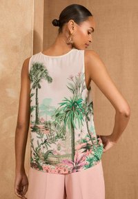 Sleeveless blouse featuring a tropical landscape print in greens, pinks, and soft beige, with a smooth texture and rounded hemline.