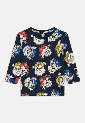 Μπλε ναυτικό πουκάμισο με μακριά μανίκια, διακοσμημένο με επαναλαμβανόμενα σκίτσα προσώπων σκύλων που φοράνε κόκκινα, μπλε και κίτρινα καπέλα πυροσβέστη και αστυνομικού.