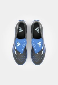 Grå og blå treningesko med en teksturert overdel, rund tå og uttalte spor. Har et distinkt logo og er av slip-on-design.