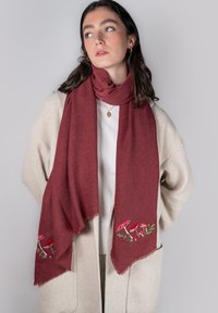Écharpe bordeaux en tissu doux, ornée de champignons rouges brodés et de feuillage vert aux extrémités, avec des bords à franges discrètes.