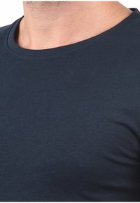 Mørk navy blå kortærmet t-shirt, lavet af blød bomuld, med rund halsudskæring og glat tekstur uden synlige mønstre eller designs.