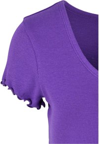 Haut violet côtelé avec un col en V et des manches courtes ornées d'une volante ondulée. Texture lisse et design ajusté.