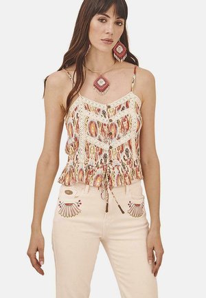 Top sin mangas colorido y con estampados, con un dobladillo con volantes, detalles de encaje y botones. Combinado con jeans rosa pálido que presentan bordados decorativos.