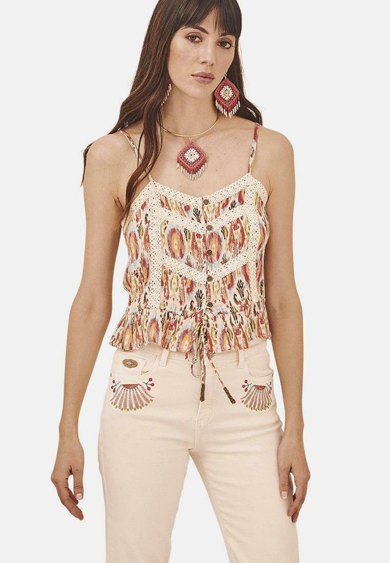 Top sin mangas colorido y con estampados, con un dobladillo con volantes, detalles de encaje y botones. Combinado con jeans rosa pálido que presentan bordados decorativos.