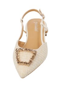 Zapato de tacón beige con punta afilada, textura de tejido y una hebilla cuadrada decorativa con acentos metálicos en la parte superior.