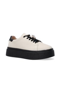 Baskets en cuir texturé blanc avec des accents noirs, dotées d'une semelle noire texturée épaisse et d'un détail décoratif en gemme sur la zone des lacets.