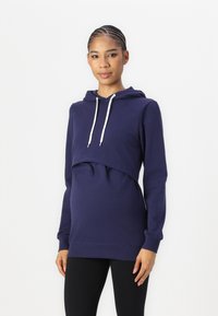Sweatshirt azul-marinho com um design cropped, cordão e mangas compridas. Feito de um tecido macio com uma textura suave e um corte descontraído.