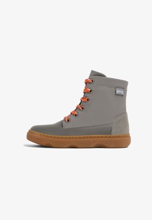 Botas de tobillo grises con cordones naranjas, suela de goma y detalles de ante suave. Presenta una punta redonda y un material superior liso.