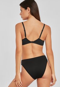 Čierny bikiny set s trojuholníkovou podprsenkou a vysokými nohavičkami, s nastaviteľnými ramienkami a hladkým matným povrchom.